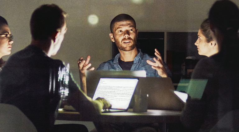 A group of men and women working late at night on a digital transformation project